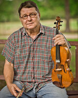 portrait of Jerry Rogers grew up in a family where, he
said, music was as important as the three
Rs. He learned fiddling from his
grandfather, Benny Rogers, who taught him
many tunes.
